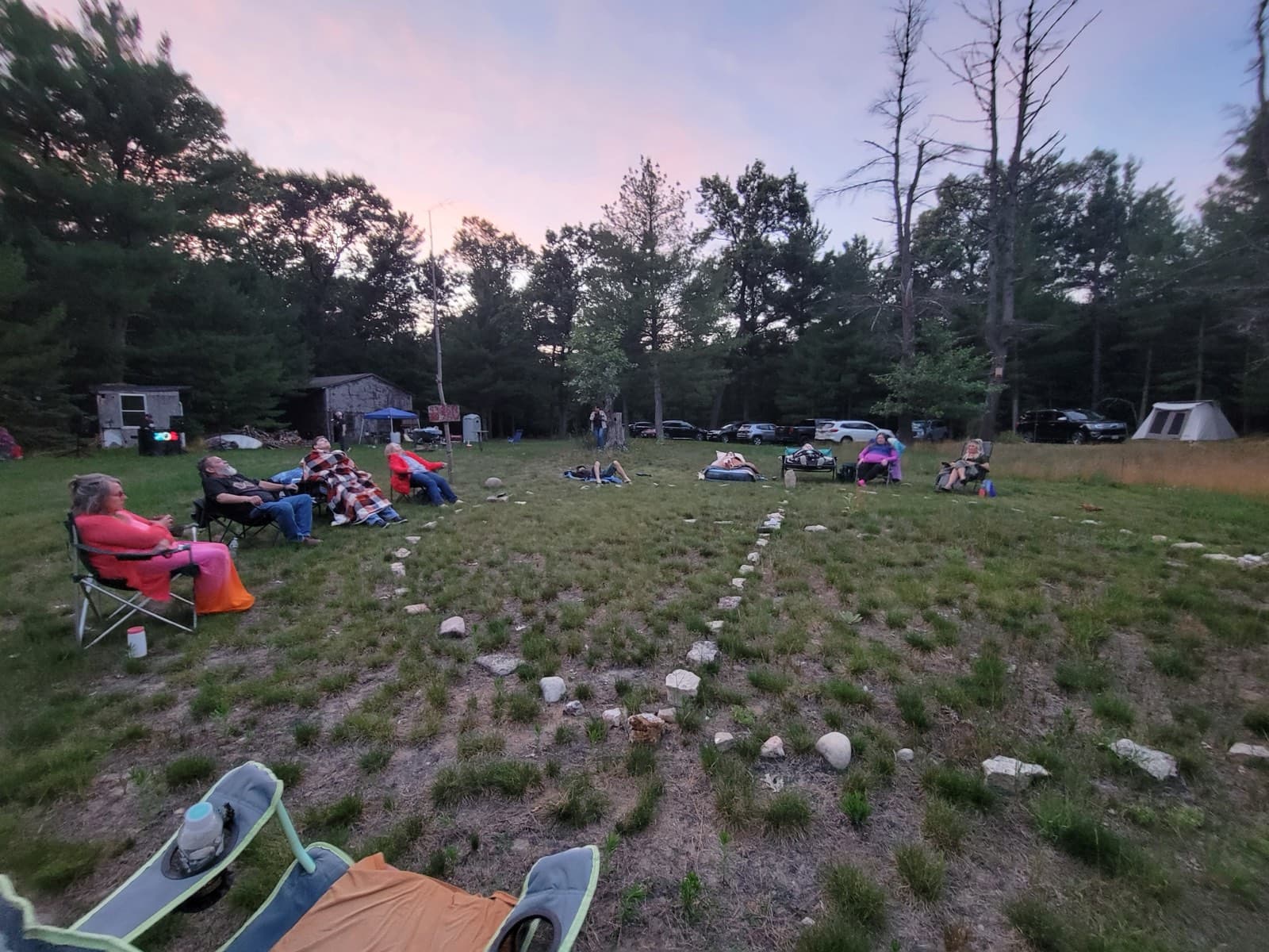 People seated in the field at dusk during Contact Camperoo